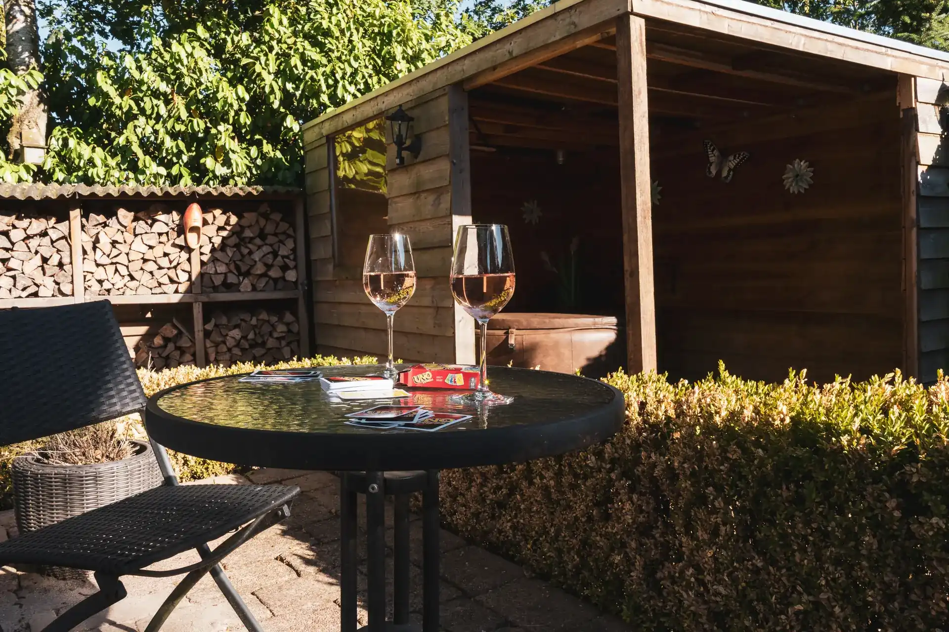 Glaasje rosé aan het tafeltje bij de jacuzzi in de tuin van Huisje Pip